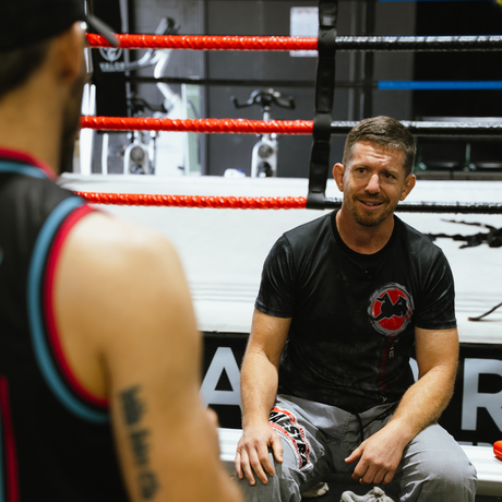 Brandt speaking with a man in a focused, supportive coaching conversation, offering steady guidance and presence.