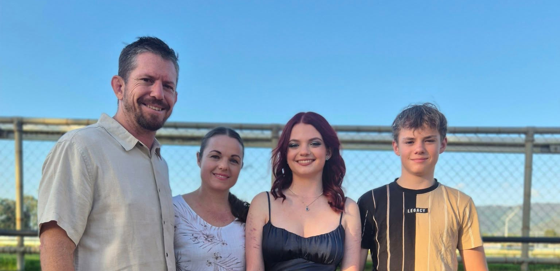 Brandt Cogill smiling with his family in a genuine, joyful moment.