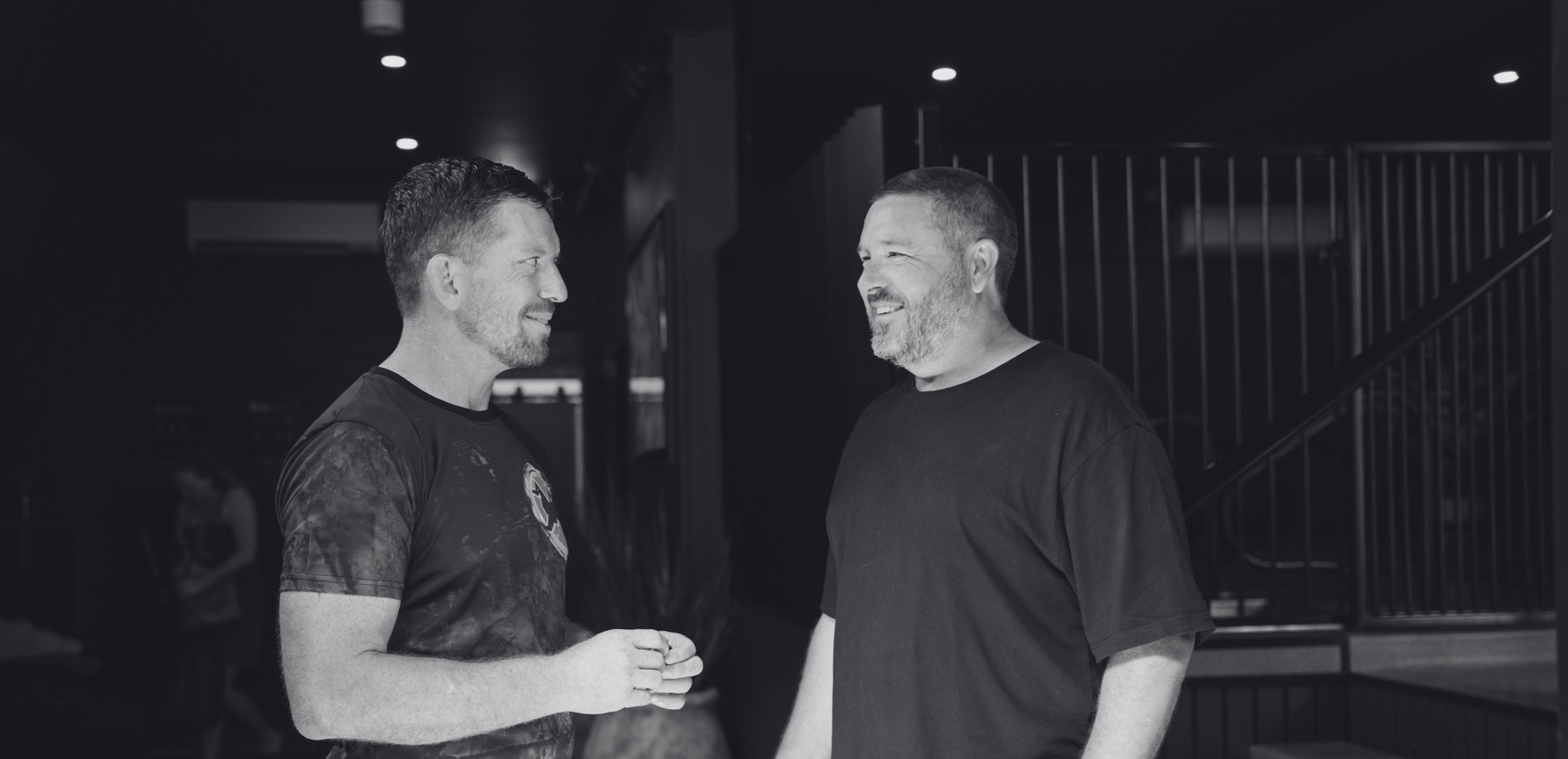 Brandt and another man sitting together in a grounded, supportive conversation, both engaged and present as they talk.